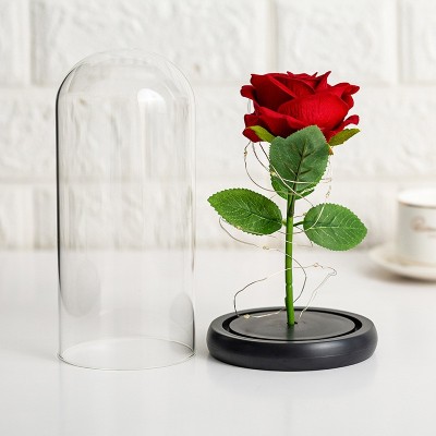 Fleur de rose allumez un cadeau de fleur dans un dôme en verre avec une boîte-cadeau